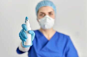 hygiene, healthcare and safety concept - close up of doctor or nurse wearing face protective medical mask or respirator for protection from virus disease with hand sanitizer. close up of doctor or nurse with hand sanitizer