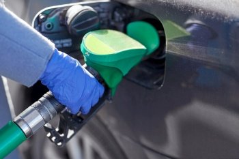 health, safety and pandemic concept - close up of hand in glove filling car with gasoline at gas station. close up of hand in glove filling car with petrol
