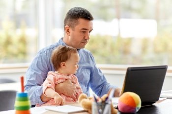remote job, multi-tasking and family concept - middle-aged father with baby working on laptop at home office. father with baby working on laptop at home office