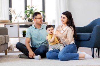 family and people concept - happy mother, father and baby son sitting on floor at home. happy family with child sitting on floor at home