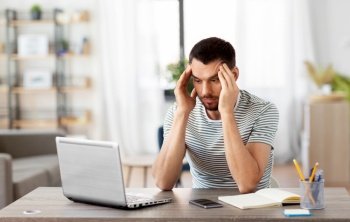remote job, technology and people concept - stressed young man with laptop computer working at home office. stressed man with laptop working at home office