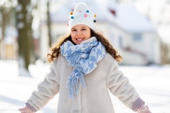 childhood, leisure and season concept - portrait of happy little girl in winter clothes outdoors at park. happy little girl in winter clothes outdoors