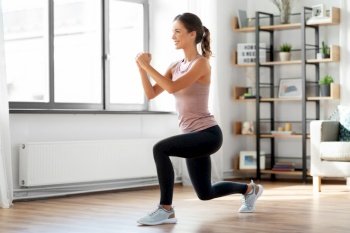sport, fitness and healthy lifestyle concept - smiling young woman exercising at home. smiling young woman exercising at home