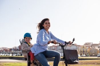 Eco-friendly Family.  Mother riding on a bicycle with young kid 