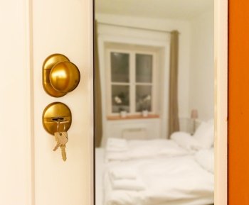 Open door to bedroom with white beds. Open door to bedroom