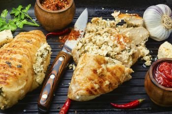 Grilled chicken breast stuffed with feta cheese.Chicken meat, sauce and seasoning in a grill pan. Chicken breast with feta cheese