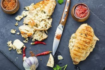 Grilled chicken breast stuffed with feta cheese and garlic.Grilled chicken fillets on slate. Chicken breast with feta cheese