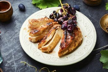 Roast chicken breast with grapes.Barbecued chicken meat.. Sliced grilled chicken breast
