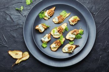 Dry pear,blue cheese and walnut appetizer.Sliced dried pear pieces. Blue cheese with dried pears and walnuts