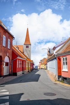Village with a church in Denmark under a blue sky in the summer