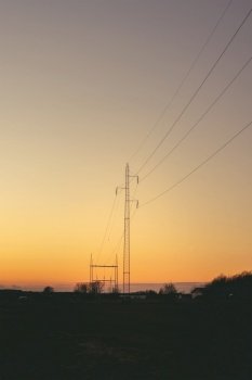 Electrical pylons at dawn in a beautiful sunset with a clear sky