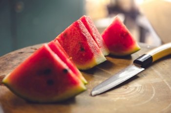 Watermelon slices in a wooden cutting board and cutlery