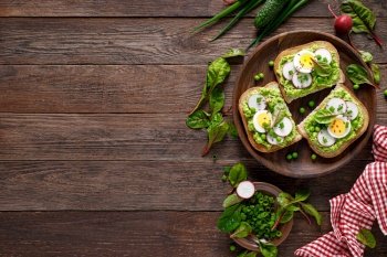 Sandwiches with wholemeal bread, hummus or puree of fresh green peas, radish, cucumber, boiled egg, green onion and chard