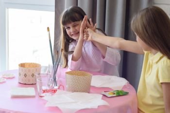 Children have fun fighting while sitting at a table in the kitchen