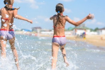 Spray soars after children run along the seashore