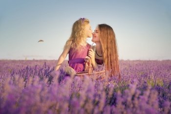 Happy mother and daughter in big lavender mountain meadow. Emotional, love and care scene.