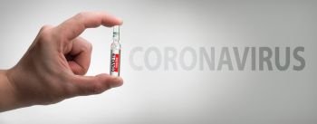 ampoule in a hand with VACCINE, Coronavirus, copy space 