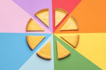 Homemade cheesecake sliced in portions on a rainbow background. Sliced cheese cake on colorful background. 8 slices of cheese tart. Famous dessert.