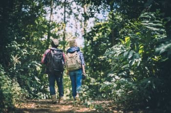 Young couple walking with backpacks in forest. Adventure hikes, Enjoy holidays together,