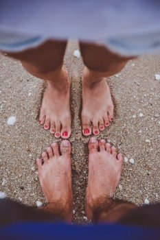 Young lover feet couple enjoying vacation on the beach together.