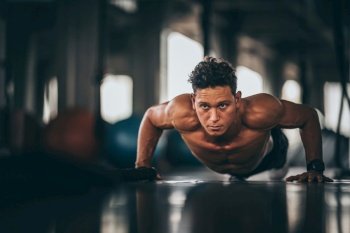 Muscular and strong athletic man doing Push up exercising in sport gym.