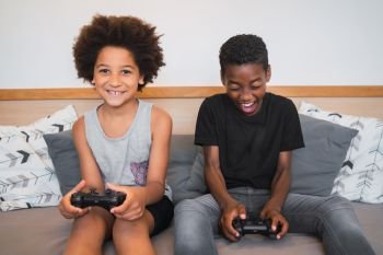 Portrait of two Afro American brothers playing video games at home. Lifestyle and technology concept.