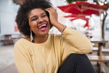 Close-up of a beautiful afro american latin woman smiling and spending nice time at the coffee shop. 