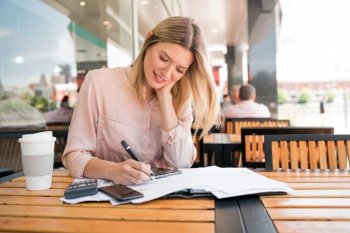 Portrait of young businesswoman checking paperwork and working at coffee shop.coffee shop. Business concept.