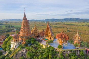 Aerial view of Big Golden Buddha Statue and pagoda in Tiger Cave Temple or Wat Tham Suea in Kanchanaburi province, Thailand. Famous tourist attraction landmark in travel trip concept.