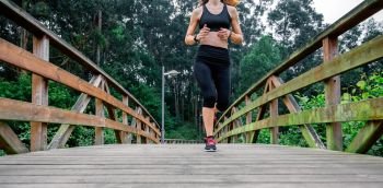 Unrecognizable athlete woman running through an urban park