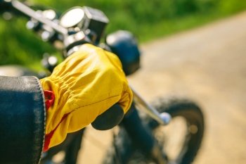 Detail of biker’s hand with gloves grabbing the handlebar of the motorbike. Biker’s hand with gloves grabbing the handlebar