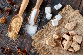 Assortment of sugar on wooden background