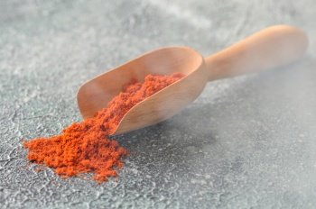 Red paprika in wooden scoop close-up