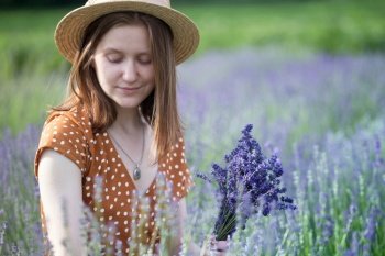 Provence - girl in a hat collects a bouquet of lavender. France
