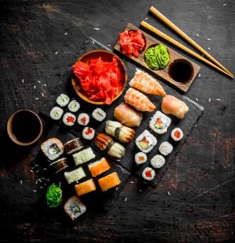 Fragrant sushi rolls with salmon, shrimp and vegetables. On dark rustic background. Fragrant sushi rolls with salmon, shrimp and vegetables.