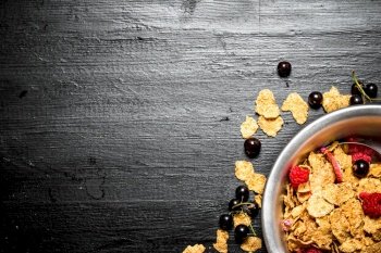 Fitness food. Muesli with a variety of wild berries. On a black wooden background.. Fitness food. Muesli with a variety of wild berries.