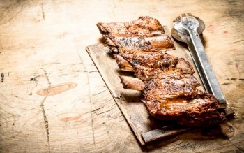 Pork ribs grilled on the Board. On wooden background.. Pork ribs grilled on the Board.