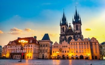 Tynsky Temple on illuminated Old Town square in Prague at sunrise