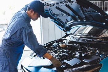 Car mechanic checking to maintenance vehicle by customer claim order in auto repair shop garage by list in clipboard. Engine repair service. People occupation and business job. Automobile technician