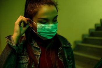 portrait of an Asian young woman. stairwell of the hospital. the girl wears a mask to avoid getting infected with the virus