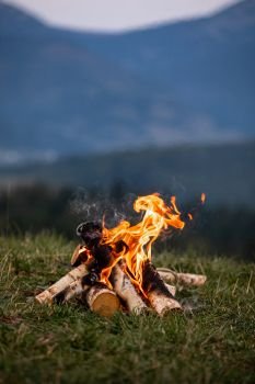Burning bonfire in the evening in the Carpathian mountains. Place for inscription.. Burning bonfire in the evening in the Carpathian mountains. Place for inscription