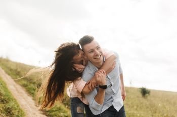 Loving young couple kissing and hugging in outdoors. Love and tenderness, dating, romance, family concept.. Loving young couple kissing and hugging in outdoors. Love and tenderness, dating, romance, family, anniversary concept.