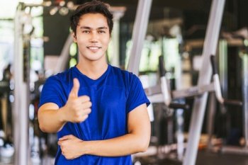Portrait of Young Asian man wearing sportswear and Raising hands like in gym fitness sport complex, posture position, sport club community, sports and healthcare concept,