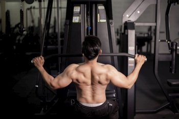 Bodybuilder man with big muscular  back in the gym 