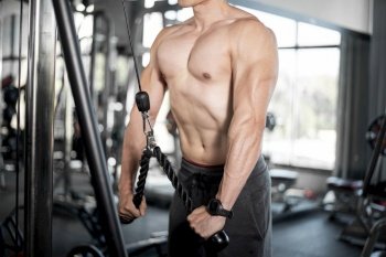 Close up muscular man is exercise in fitness gym 