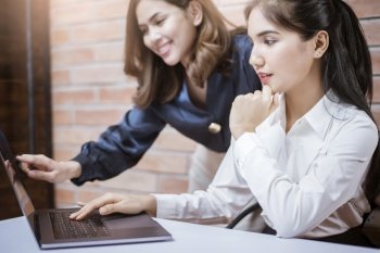 Two young business women are analytics   information on laptop screen, business meeting . Two young business women are analytics   information on laptop screen, business meeting concept 