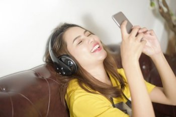 Beautiful woman is listening music in home 