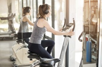 Pretty young sport woman is exercise on bicycle in gym, Healthy lifestyle 