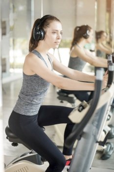 Pretty young sport woman is exercise on bicycle in gym, Healthy lifestyle 