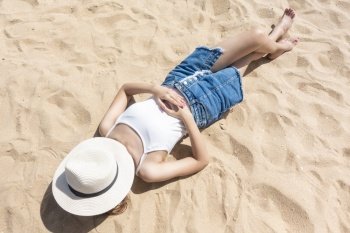 A woman is laying on the Beach 